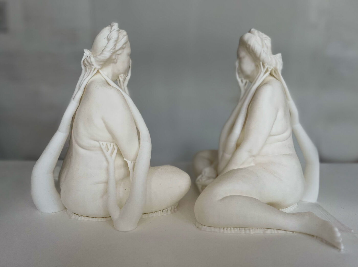 The same pair of seated figures, seen from behind, facing each other.